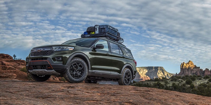 Ford Explorer Timberline SUV parked on a rocky overlook with roof-mounted cargo storage