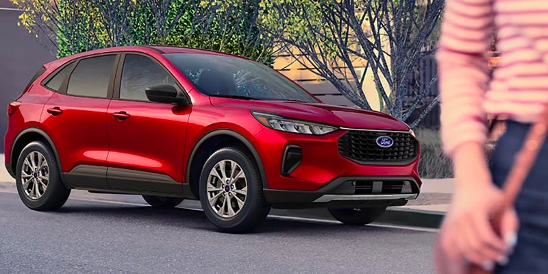 A red Ford compact SUV/crossover is parked or stopped on a paved street