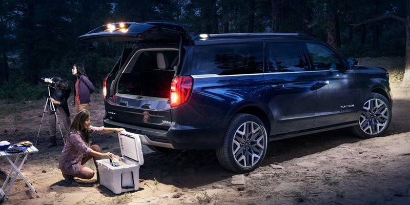 Ford Expedition SUV parked at a campsite with the rear liftgate open, showcasing cargo accessibility