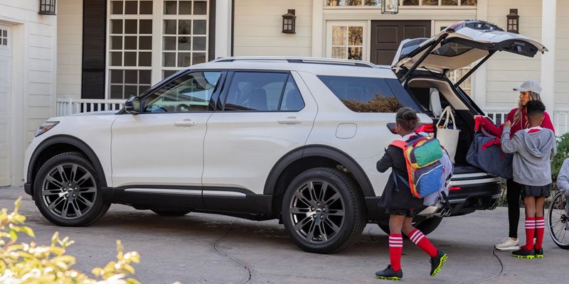 2026 Ford Explorer with children loading backpacks in driveway